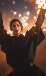 a woman holds up a fire ball with her arms