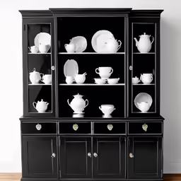a black china cabinet filled with white dishes