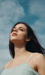 a woman looking upwards with her hair flying behind her