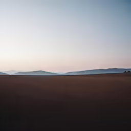 the sun is coming down over the mountains