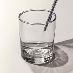 the shadow of a glass is cast on a table