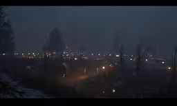 lights are shining on the road at night in a rainy city