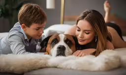 young woman lying down with dog on white rug