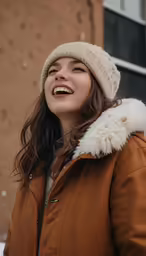 smiling woman with large fur - lined coat looking off to the side