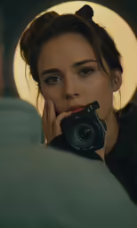 a woman holding a camera up to her face