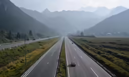an empty highway with a line of cars going around