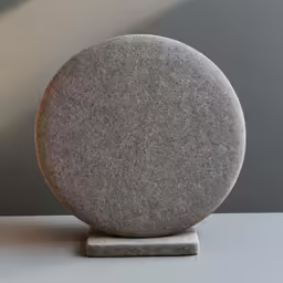 a stone statue sits on top of a marble table