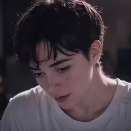 a boy is looking down with serious expression