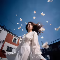 there is a woman wearing a long white coat and flying white butterflies