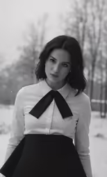woman in dress standing in snow wearing a tie