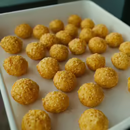 several baked balls that are on a tray