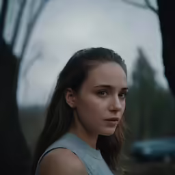 the woman is wearing a gray dress outside