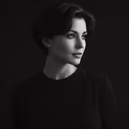 a woman in a black top and a dark background
