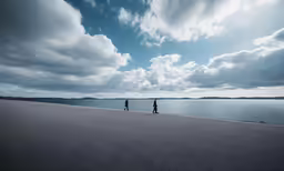 two people stand facing a large body of water