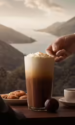 someone grabbing the spoon with a chocolate beverage in their hand