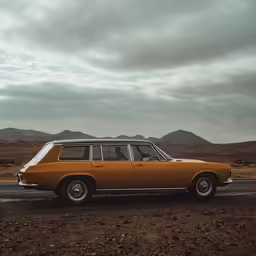 an orange station wagon sits alone by the desert road