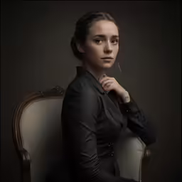 a young woman posing for a photo while wearing a black dress
