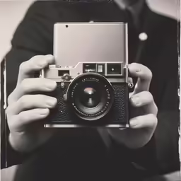 a person holding a camera and posing for a photo