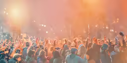 crowd of people standing around with lights in background