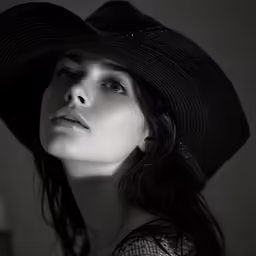 a woman wearing a hat sitting next to her face