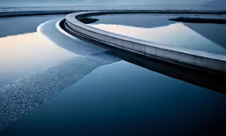 a curved waterway next to a large pond