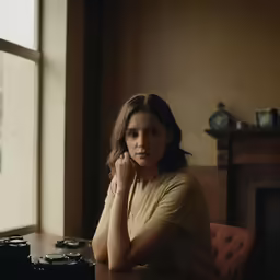 a woman sitting at a table with a camera