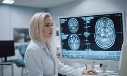 a female doctor looking at the screen as she looks at a monitor