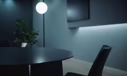 an empty table with chairs under a light fixture