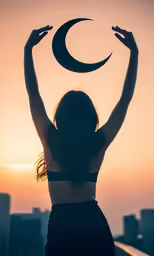 a woman holds the crescent sign up while she stands with her hands above her head
