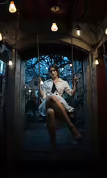 girl with eyeglasses sitting on swings with some strings
