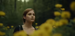 woman staring into the distance in a field of flowers
