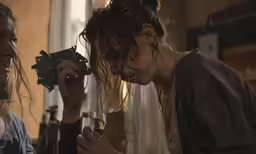 a girl is showing another woman how to put something on her face
