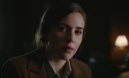 a woman looking to her left in a dark room