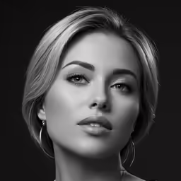 a woman with short blonde hair wearing large earrings