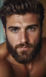 a man with curly hair and a beard looks into the camera