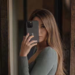 a girl in grey shirt looking at her phone
