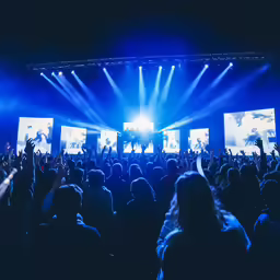people on a stage are standing and clapping