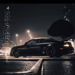 a parked black car at night by some street lights