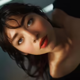 a woman wearing a black top is posing with her hair down