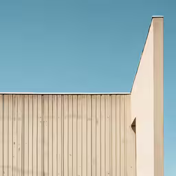 a tall white building with a skateboard leaning up against it