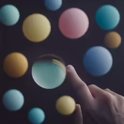 a hand pointing to several colored circles