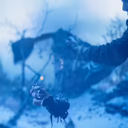 a hand holding a camera lens for something