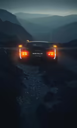 a car that is parked in the grass by some mountains