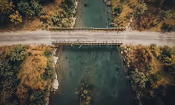 an overhead shot of a road bridge near a river