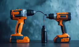 two orange and gray tools sitting on a table