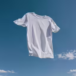 white tshirt being hung from the clothesline in front of a blue sky