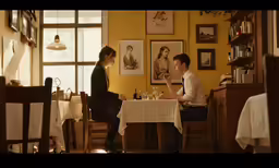 two people sitting at a table in a restaurant
