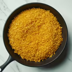 some yellow rice is in a black skillet