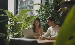 a man and woman looking at a laptop together