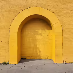 a yellow wall has an archway shaped doorway